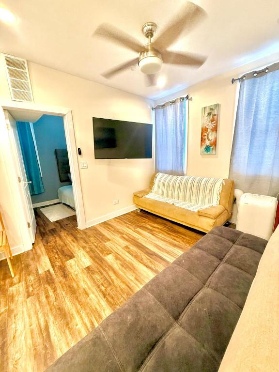 a living room with a couch and a tv at Chicago Coach Casa in Chicago