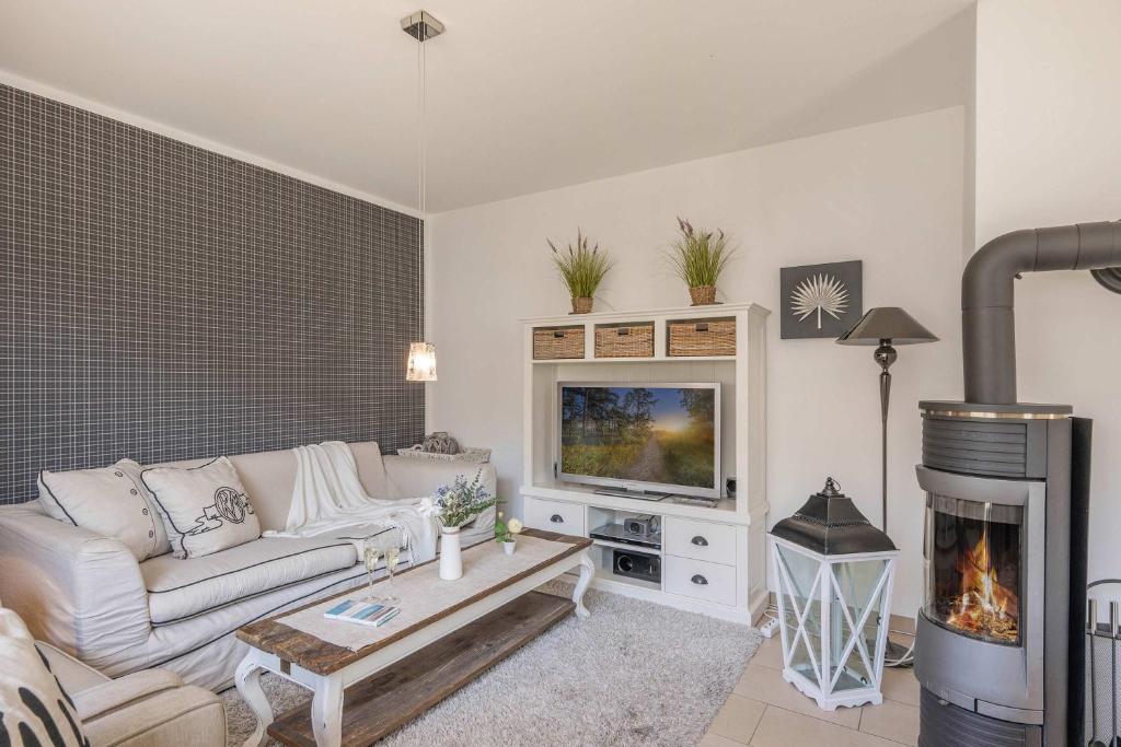 a living room with a couch and a fireplace at Reethus am Küstenwald in Koserow