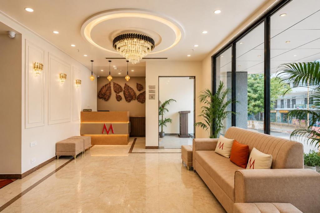 an office lobby with a couch and a chandelier at Mosaic Connect Ayodhya in Ayodhya