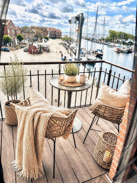 a balcony with a table and chairs and a harbor at meerHAFEN in Orth