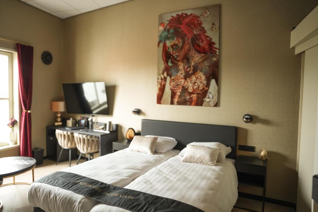 a bedroom with two beds and a painting on the wall at Stadshotel Jacob Cats in Brouwershaven