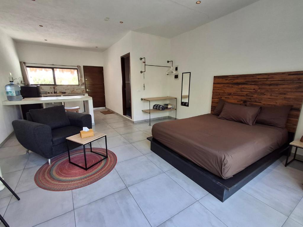 a bedroom with a bed and a couch and a table at Casa Pavezin in Mahahual
