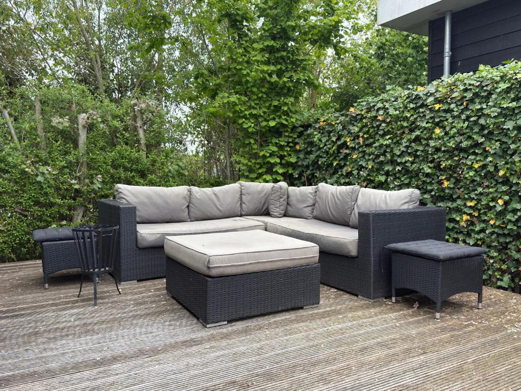 a couch and two chairs on a deck at Natuurhuisje Abcoude - De Smient - Best Family Stay in Abcoude