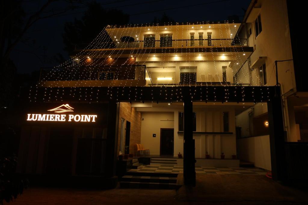 a building with a lit up sign in the dark at Lumiere Point Yercaud in Yercaud