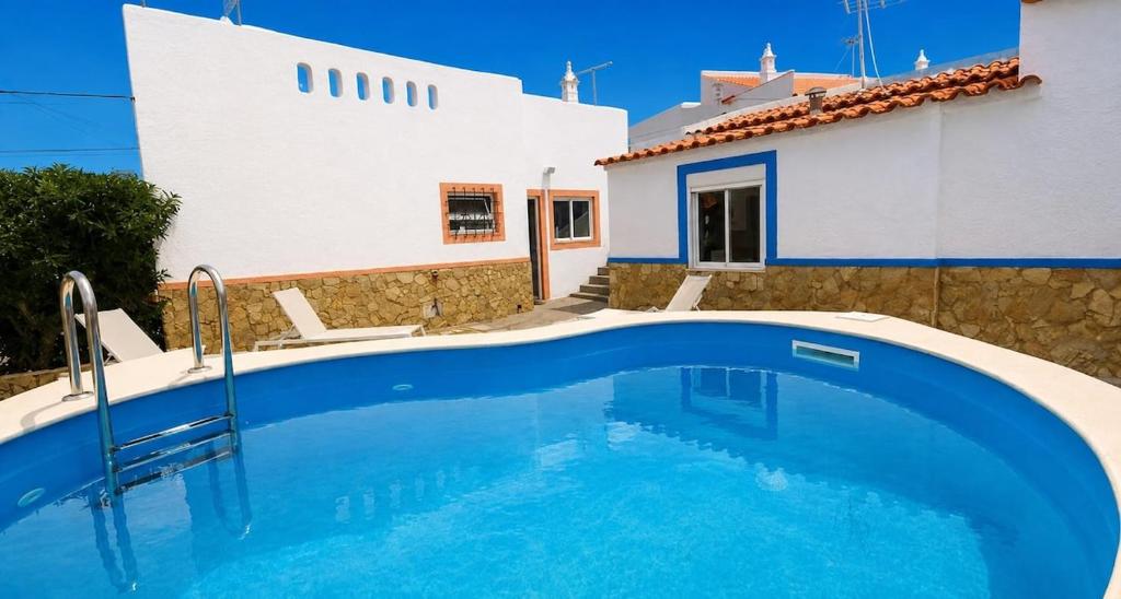 a large blue swimming pool in front of a house at Viila Fernandes with Pool in Pera in Pêra