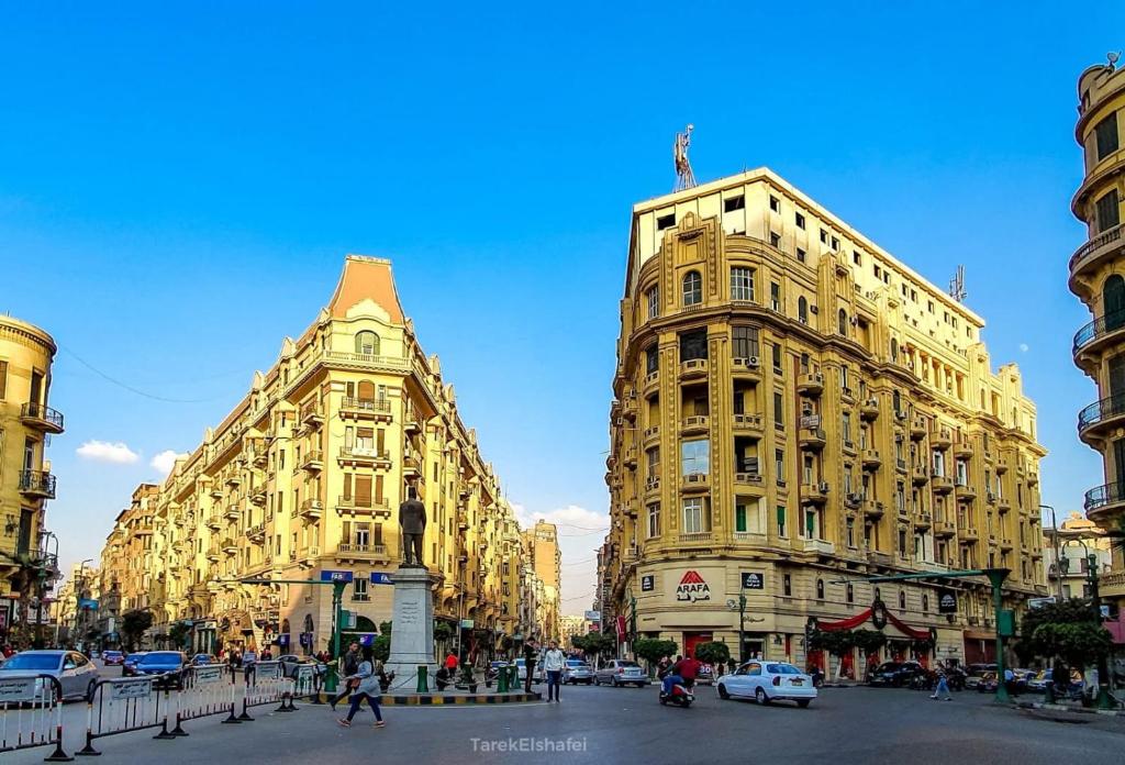 a large yellow building on a busy city street at pal ace talaat harb in Cairo