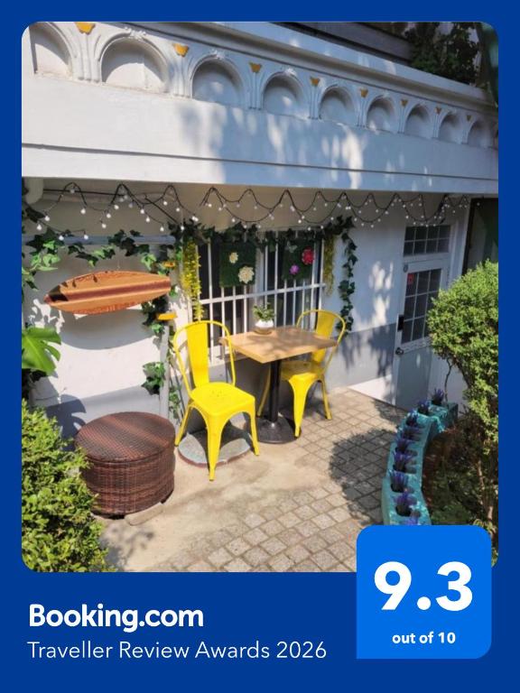 a patio with a table and two yellow chairs at Newly renovated hidden gem #2 in Seoul