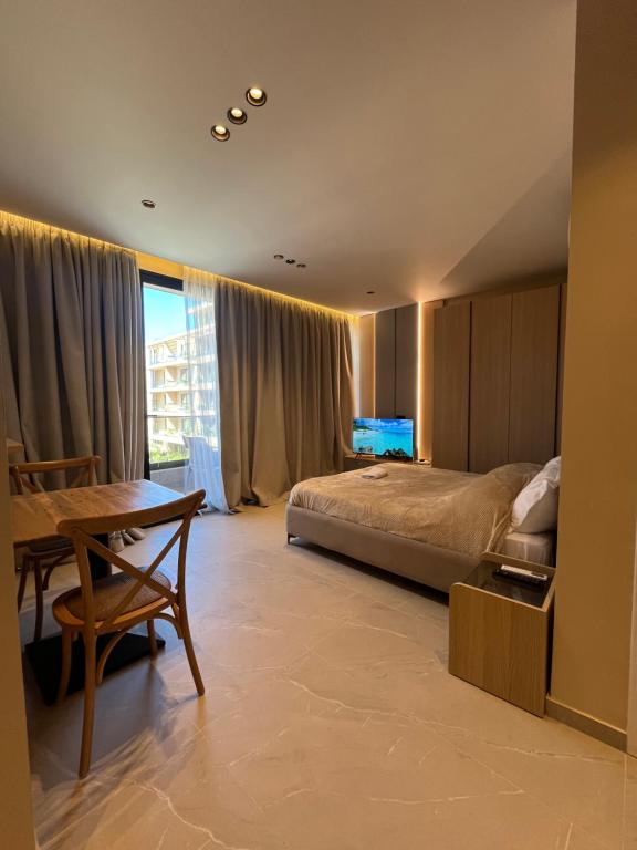 a bedroom with a bed and a desk and a table at Ciel Apartement in Orikum