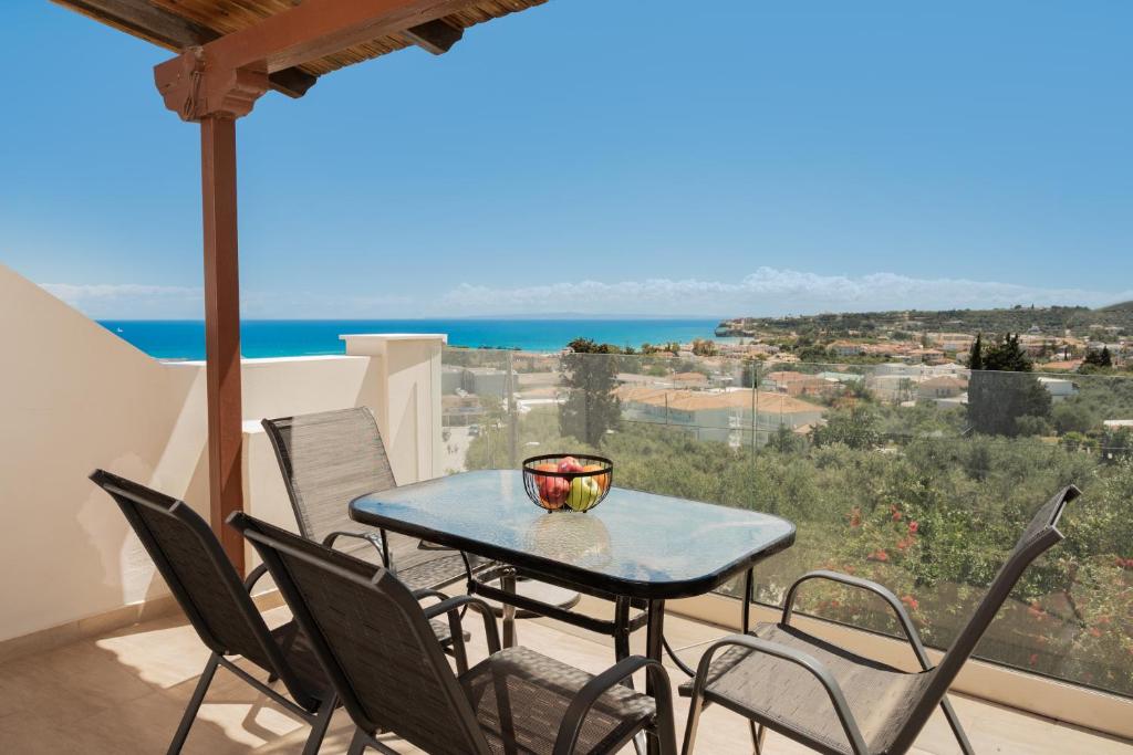 a table and chairs on a balcony with a view of the ocean at Yiannis Studios in Tsilivi