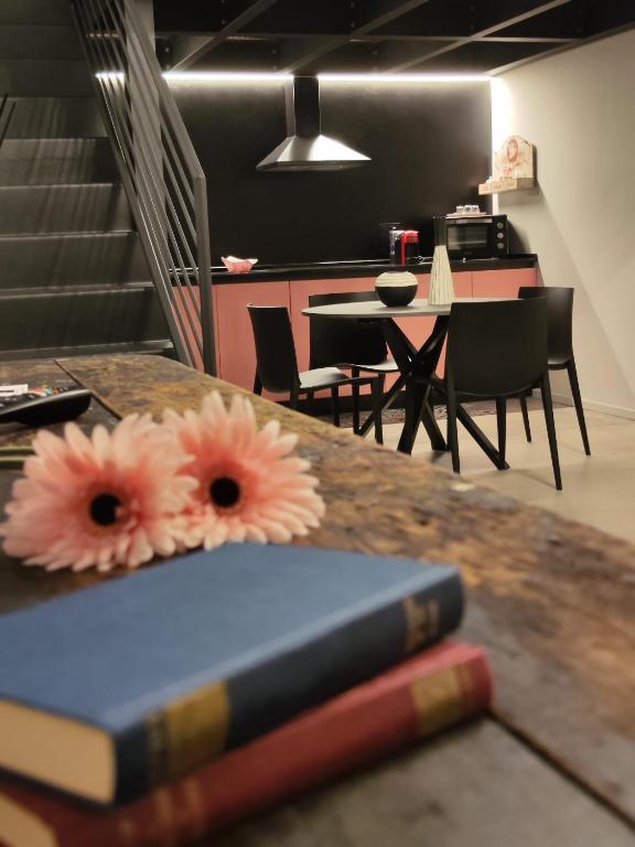 a book sitting on a table with flowers on it at Loft Deluxe centralissimo-Antica Vetreria in San Benedetto del Tronto