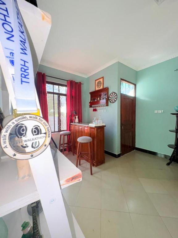 a view of a living room with a watch on a shelf at Maliasili Apartments in Mwanza