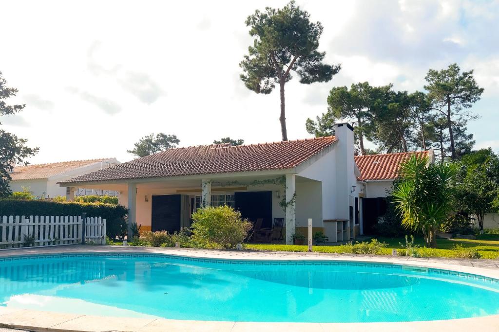 a house with a swimming pool in front of a house at Verdizela Pool & Barbecue Villa in Corroios