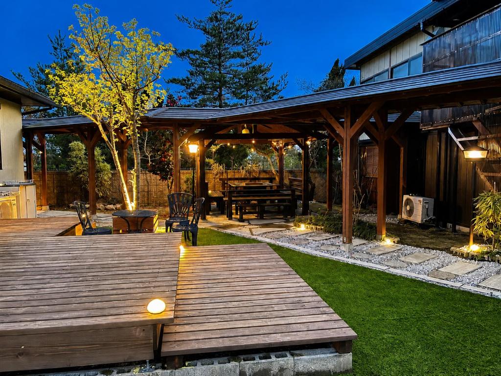 a wooden deck with a picnic table in a backyard at Biwako Villa 縁 in Takashima