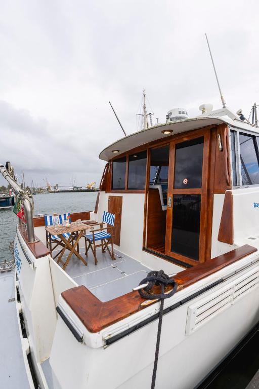 a white boat with a table and chairs on it at Classic Seadream Yacht in Figueira da Foz