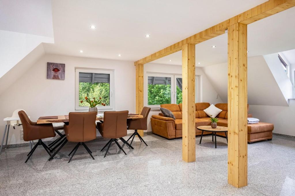 a dining room and living room with a table and chairs at Ferienwohnung Schrödter in Schramberg