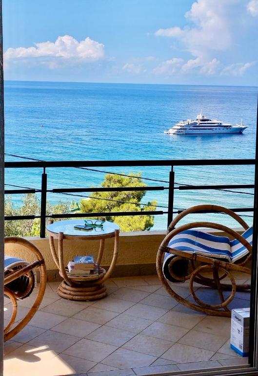 a balcony with a view of the ocean and a cruise ship at Daphne Glyfada Corfu in Glyfada