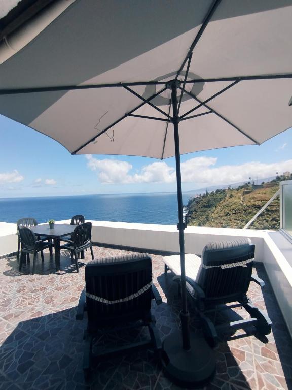 a patio with a table and chairs and an umbrella at La Mar in Los Realejos