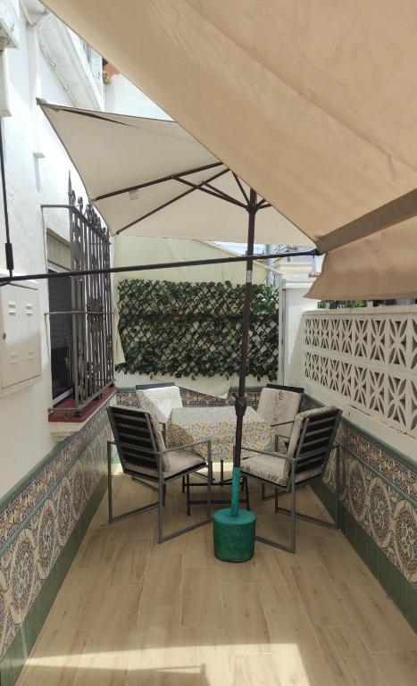 a patio with chairs and a tree in a courtyard at Casa José in Rota