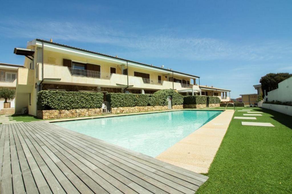 a swimming pool in front of a house at GuestHost - Gabbiano Lovely Flat with Veranda in Palau