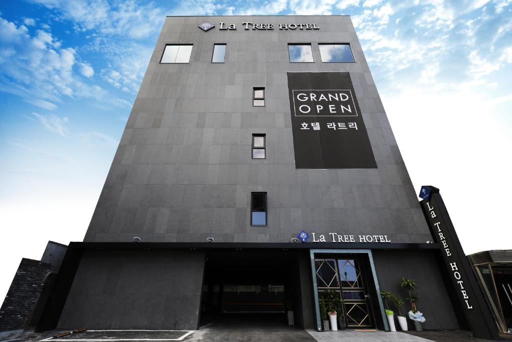 a tall building with a sign on it at Cheonan La Tree Hotel in Cheonan