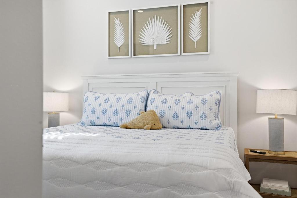 a bedroom with a white bed with blue pillows at Spacious 3BR - Pool - Beach Nearby in Pass Christian