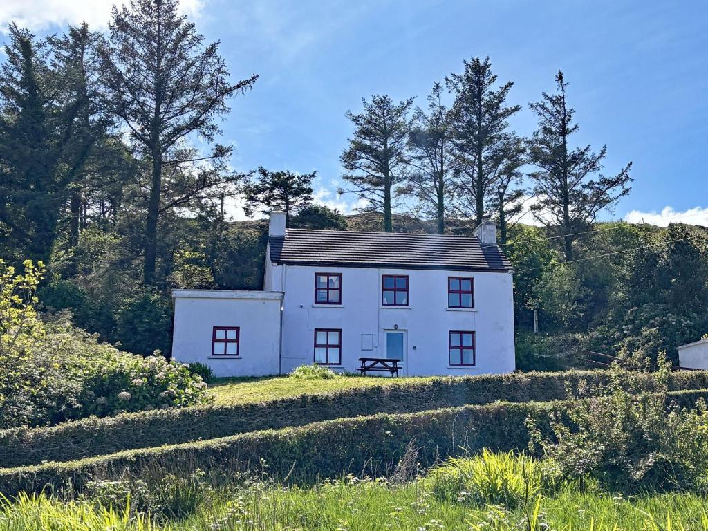 a white house in the middle of a field at Cottage 507 - Renvyle in Renvyle