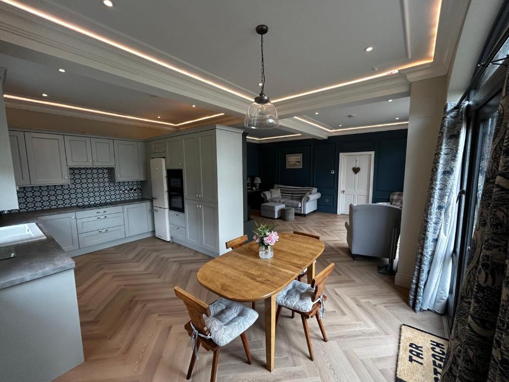 a kitchen and dining room with a wooden table and chairs at Teach na Radharc in Raheen
