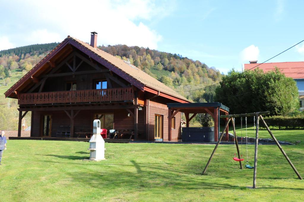 a house with a playground in front of it at Chalet Heidi in Ventron