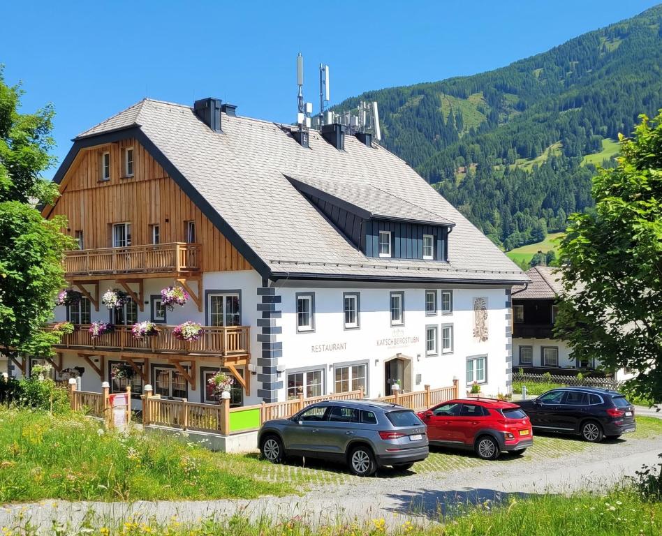 a large building with cars parked in front of it at Katschbergstubn in Sankt Michael im Lungau