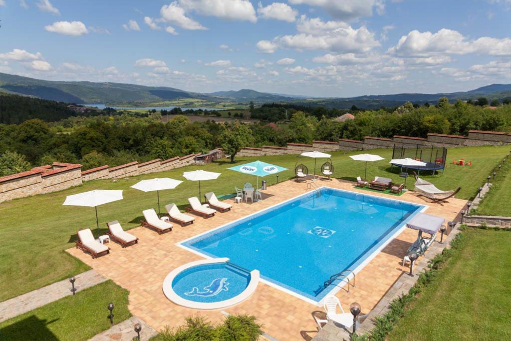 an overhead view of a swimming pool with chairs and umbrellas at Любомировата къща in Sredni Kolibi