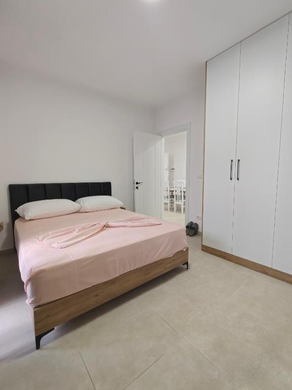 a bedroom with a large bed with pink sheets at DS apartments in Golem