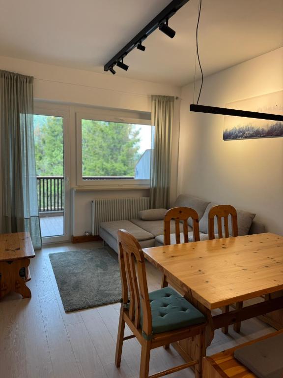 a living room with a table and chairs and a couch at Tra Neve e Lago Mountain Apartment in Sella Nevea