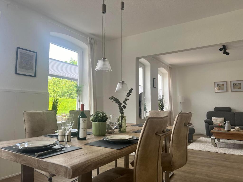 a dining room with a wooden table and chairs at Ferienwohnung M2 in Husby