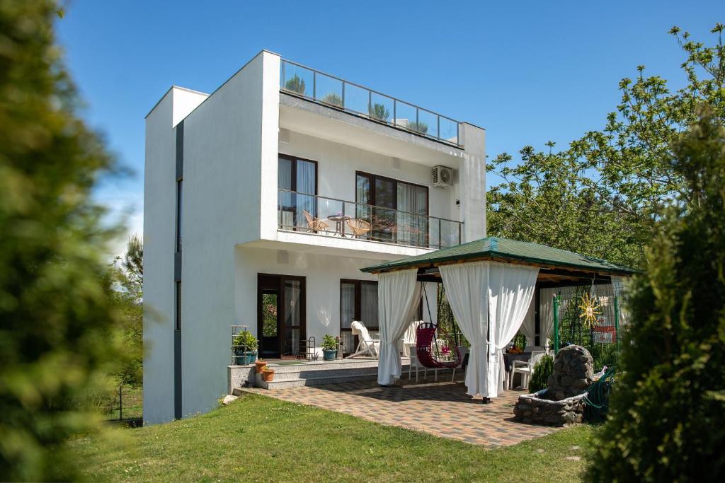 a white house with a gazebo in front of it at VILLA EVA - 5 min to the beach in Shekhvetili