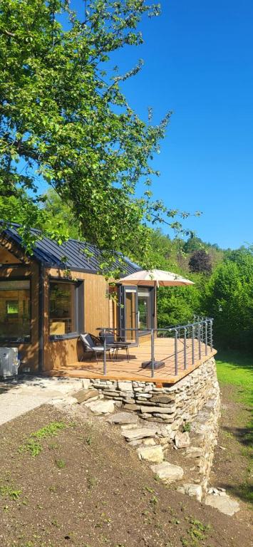 a house with a deck with a table and an umbrella at Tinyhouse am Bach, 3144 Wald in Wald