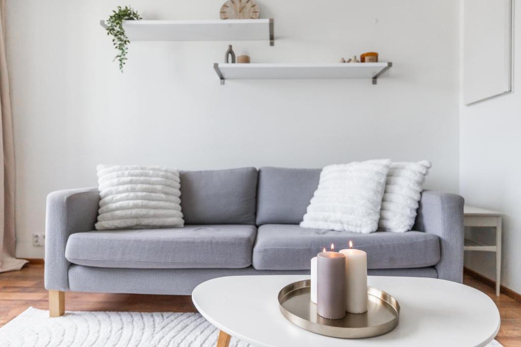 a living room with a couch and candles on a table at Central Studio I by Elys Collection in Rovaniemi