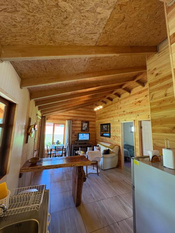 a kitchen and living room with wooden walls at Parcela Peumayen Casa 4 in Pucura
