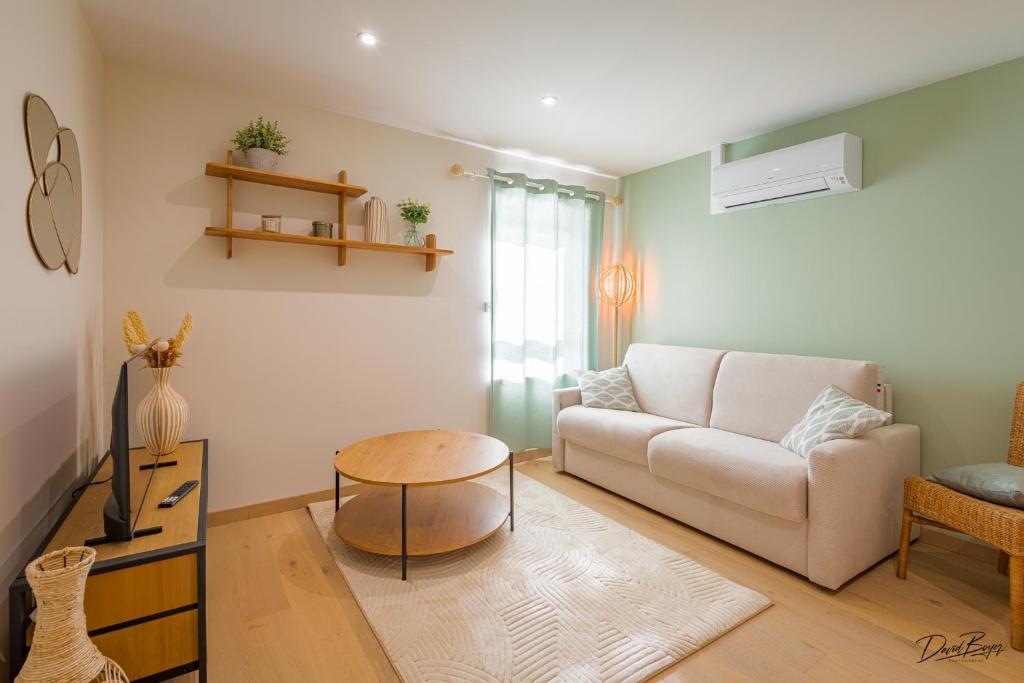 a living room with a couch and a table at Domaine de cézille-Appart hôtel le Moulin du lac "Paul" in Jayat