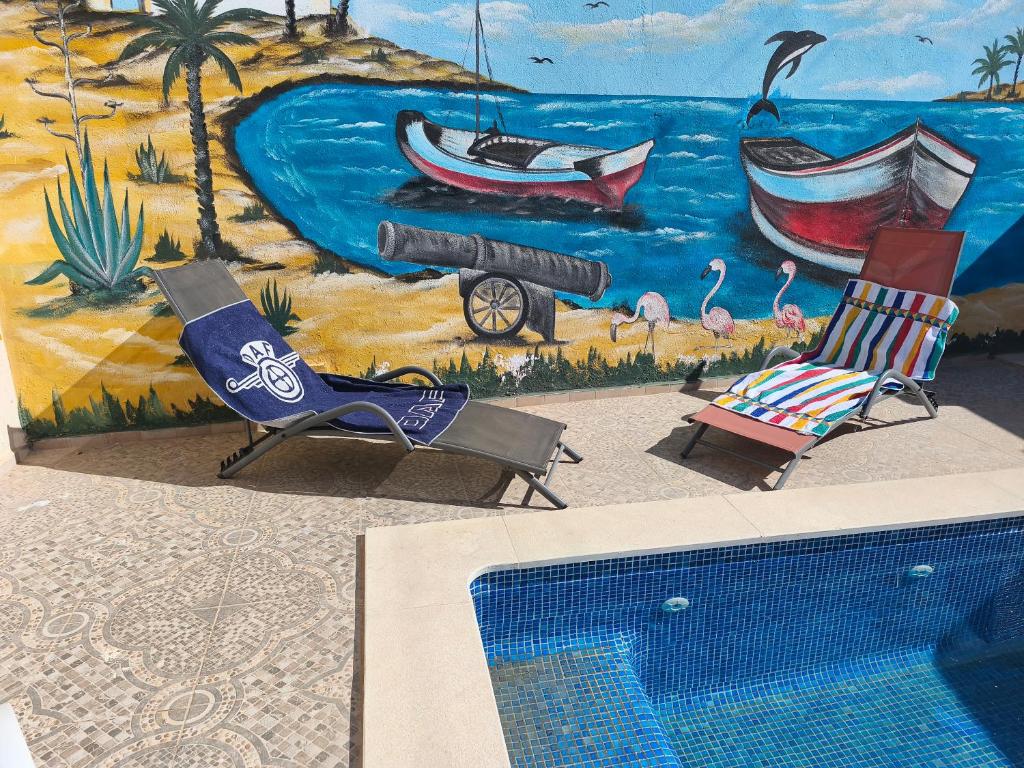 ein Wandgemälde, das einen Strand mit Stühlen und einem Schwimmbecken zeigt in der Unterkunft Djerba Aldo Piscine in Houmt Souk
