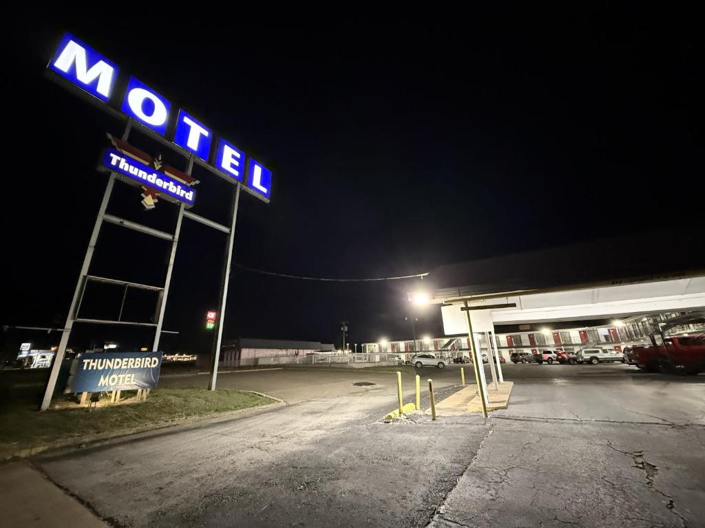 a neon sign for a mobil gas station at night at Thunderbird Motel Hillsboro in Hillsboro