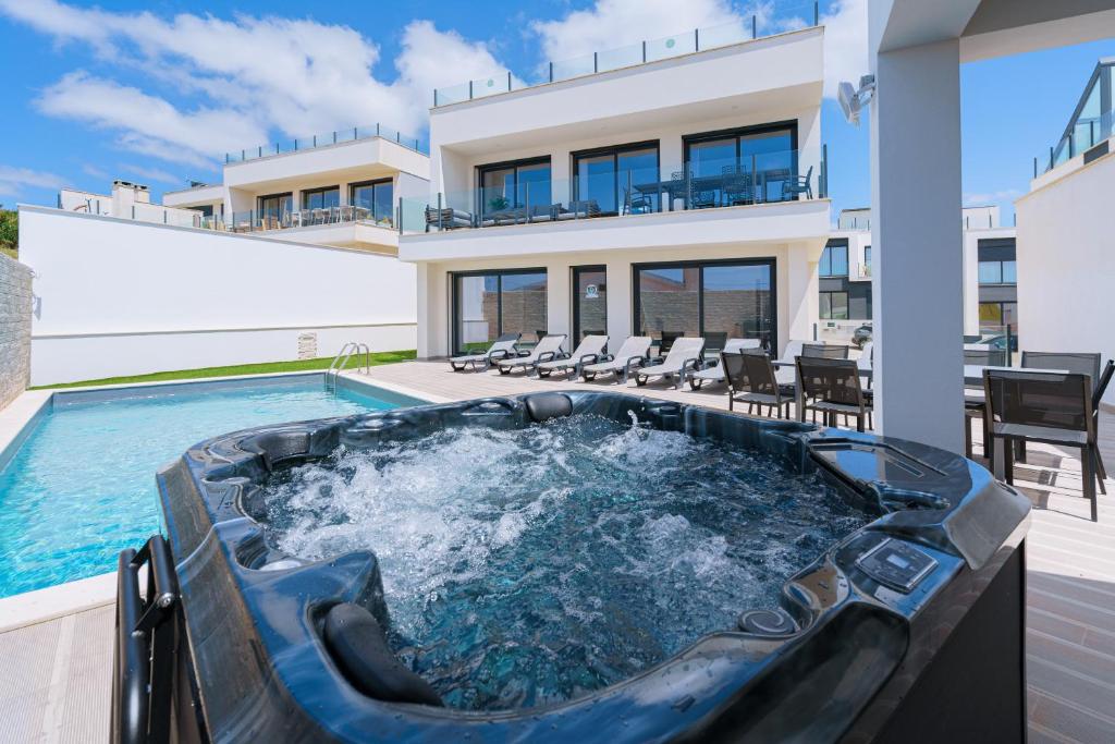 a hot tub in the backyard of a house at Eden Villa, with jacuzzi and ocean view in Casal do Cigano