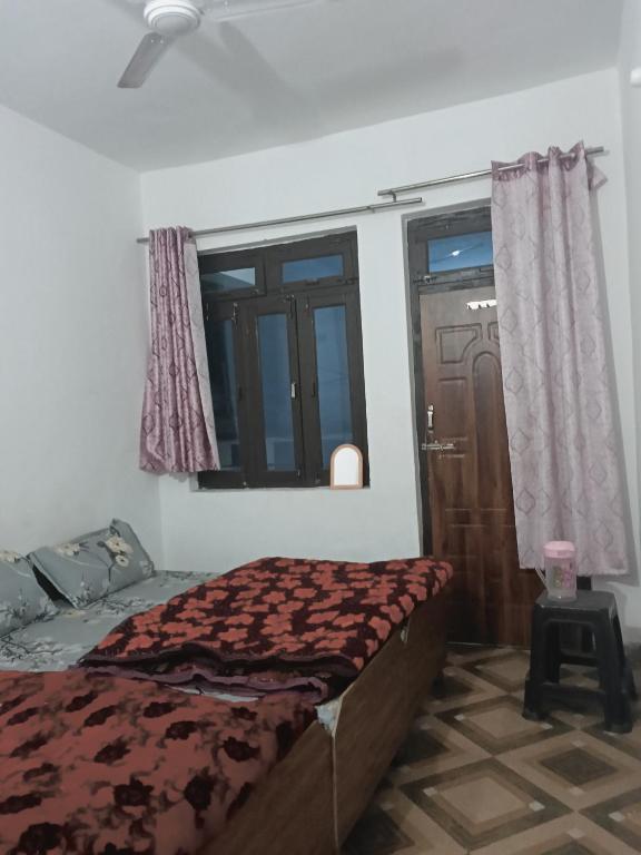 a bedroom with a bed and a window at Punchkedar in Phata