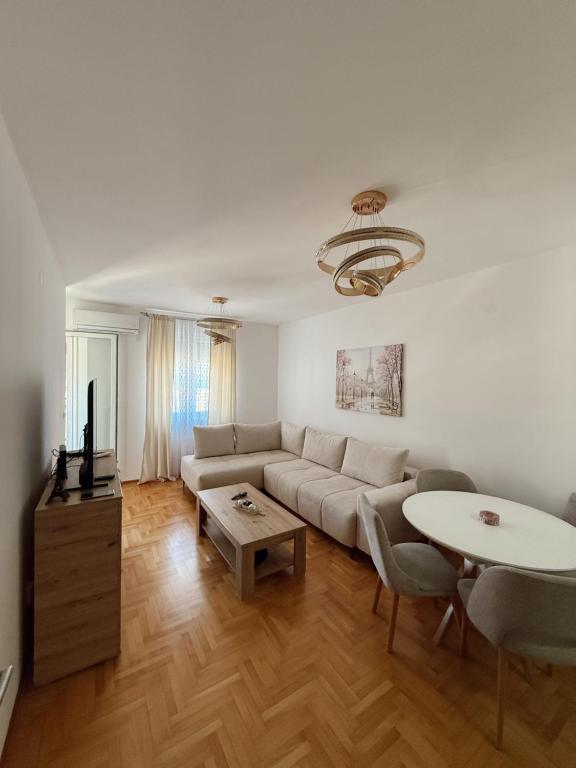 a living room with a couch and a table at Sky & Sea View Apartment Budva in Budva