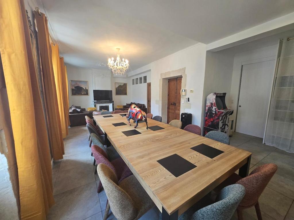 a large wooden table with chairs in a room at Cocon des Arènes Nîmes Centre 18 couchages in Nîmes