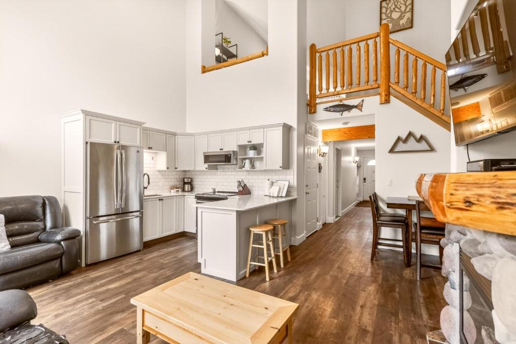 a kitchen and living room with white cabinets at Riverside Condos by Fernie Central Reservations in Fernie