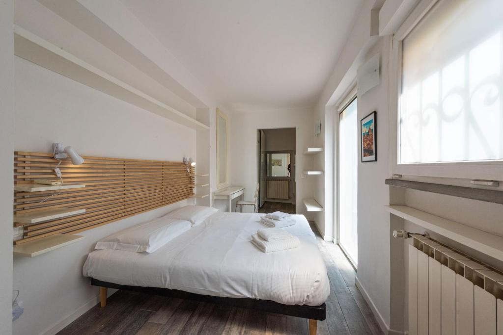 a bedroom with a white bed and a large window at Vettori Hideaway by MMega in Florence