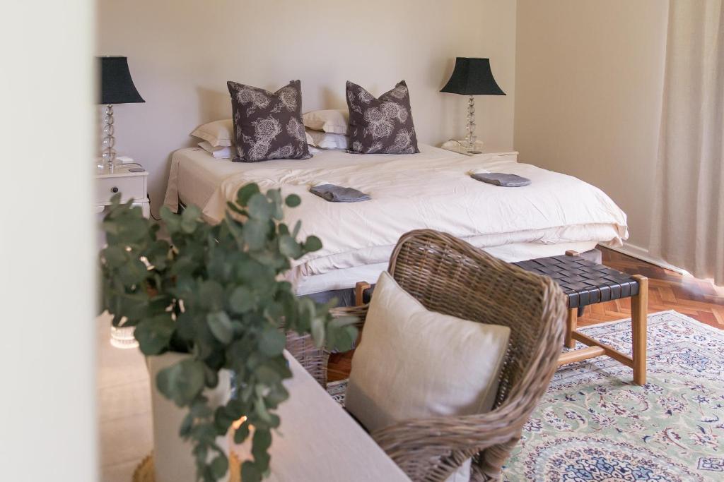a bedroom with two beds and a table with a plant at Clivedon Cottage in Sunland