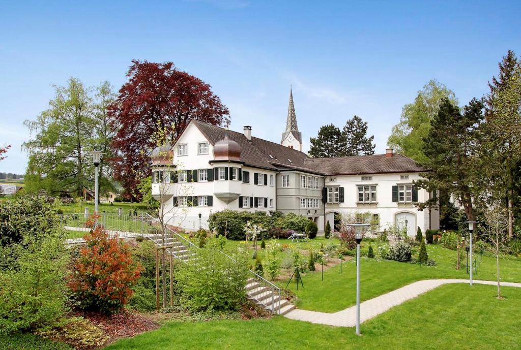 a large white house with a garden in front of it at Appartement "Suite Seeliebe" in Tägerwilen