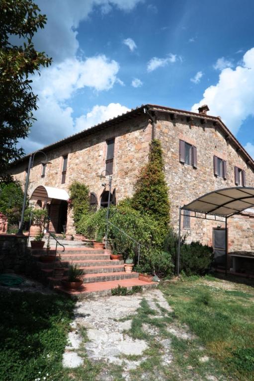 an old brick building with stairs in front of it at Holistic Hotel MadreSelva in Casole dʼElsa