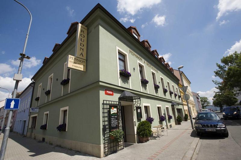 ein grünes Gebäude an der Straßenseite in der Unterkunft Penzion a Restaurace Stará Roudná in Pilsen